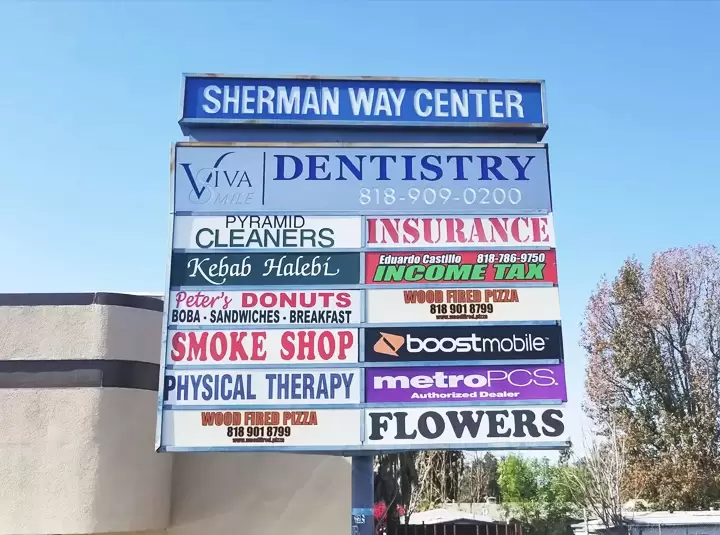 Outdoor pylon sign for Sherman Way Center listing various businesses available at the location