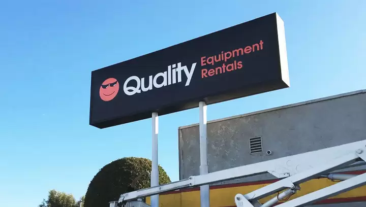 Twin-poled pylon sign featuring the company name in white and orange on black background