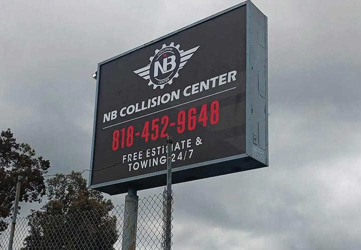 Pylon sign installed outdoors for NB Collision Center displaying the company logo and contacts