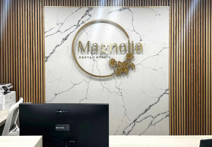 Magnolia Dental Studio lobby sign displaying the brand name made of acrylic and aluminum