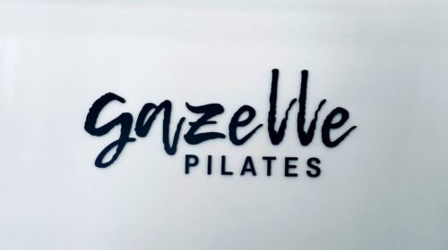 Gazelle Pilates custom lobby sign mounted to the wall