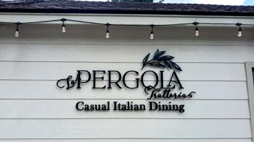 La Pergola Trattoria restaurant sign on exterior wall