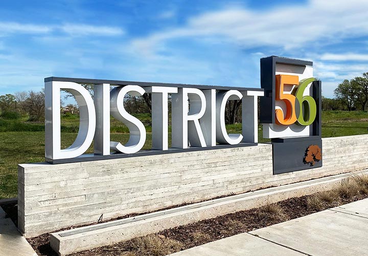 District 56 community signage installed outdoors made of mixed products for branding