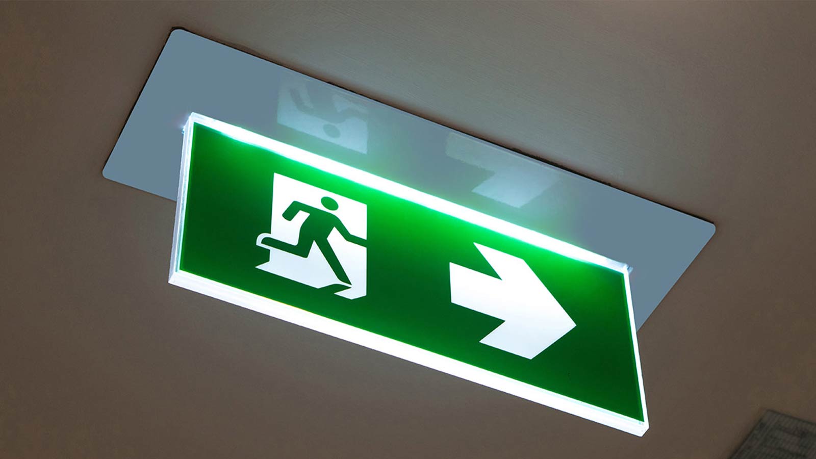 green and white illuminated exit sign
