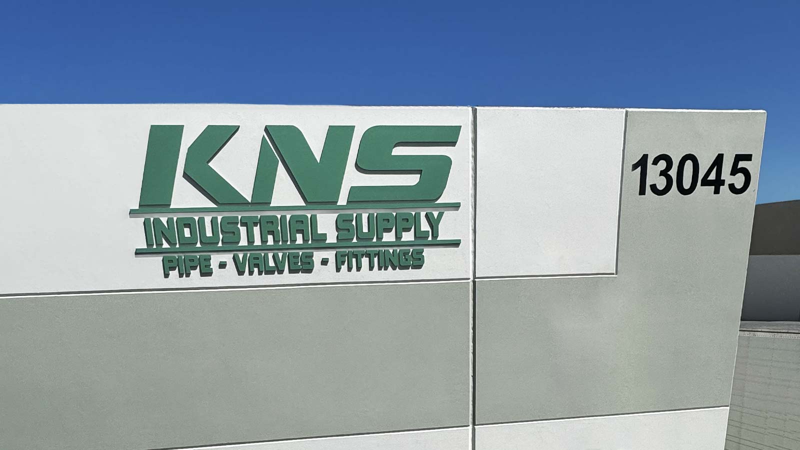 kns pvc sign installed on the outdoor wall
