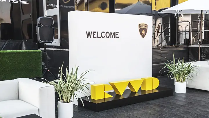 Custom outdoor signage for an event reading Welcome and featuring brand logo for Lamborghini