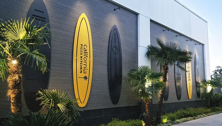 California Pizza Kitchen metal outdoor signs in yellow and black surfboard shapes